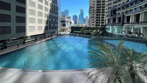 Une piscine sur le toit, entourée de gratte-ciel, offrant une vue dégagée sur le panorama urbain.
