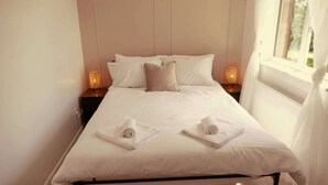 A neatly made bed with white linens, two bedside tables with lamps, and a window with curtains. - Home In Longwell Green  Inbetween Bristol and Bath (Longwell Green)