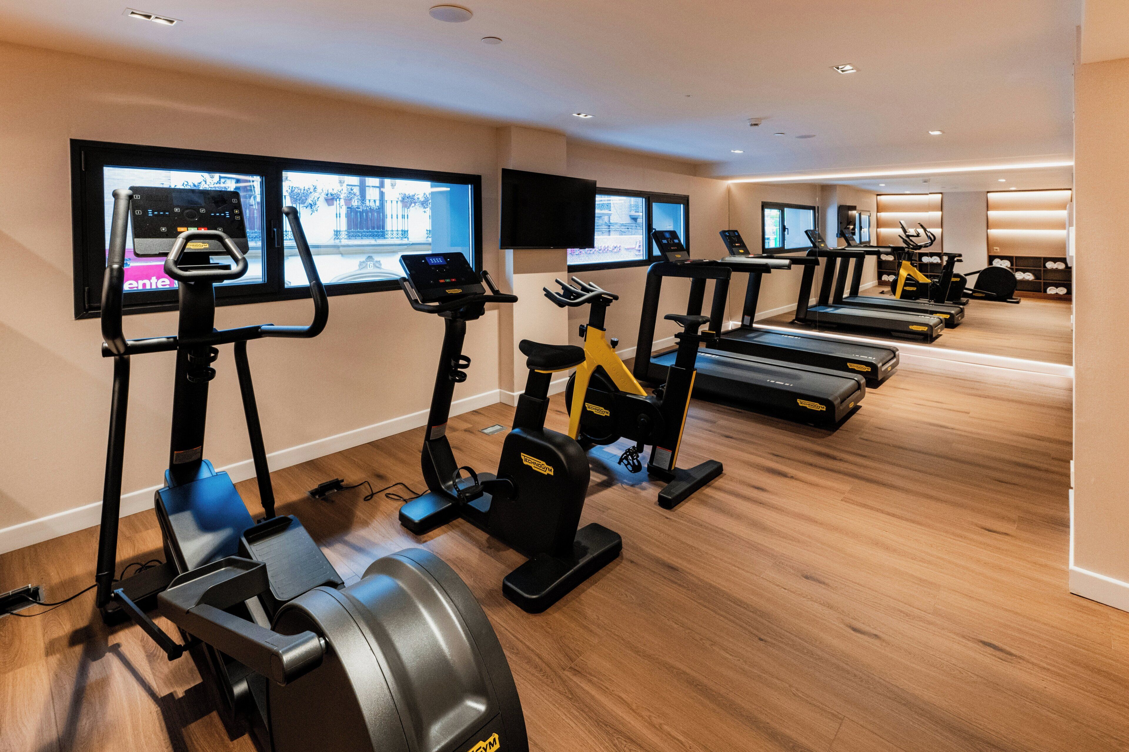 Ein Fitnessstudio mit Laufbändern, Ergometer und Crosstrainern.
