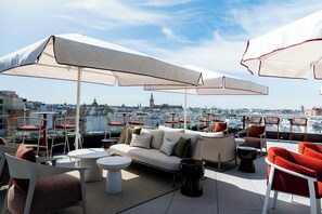 A rooftop terrace with outdoor seating, umbrellas, and a city view. - Sercotel Sevilla Don Luciano (Seville)