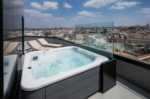 Un jacuzzi en un balcón con vistas a la ciudad.