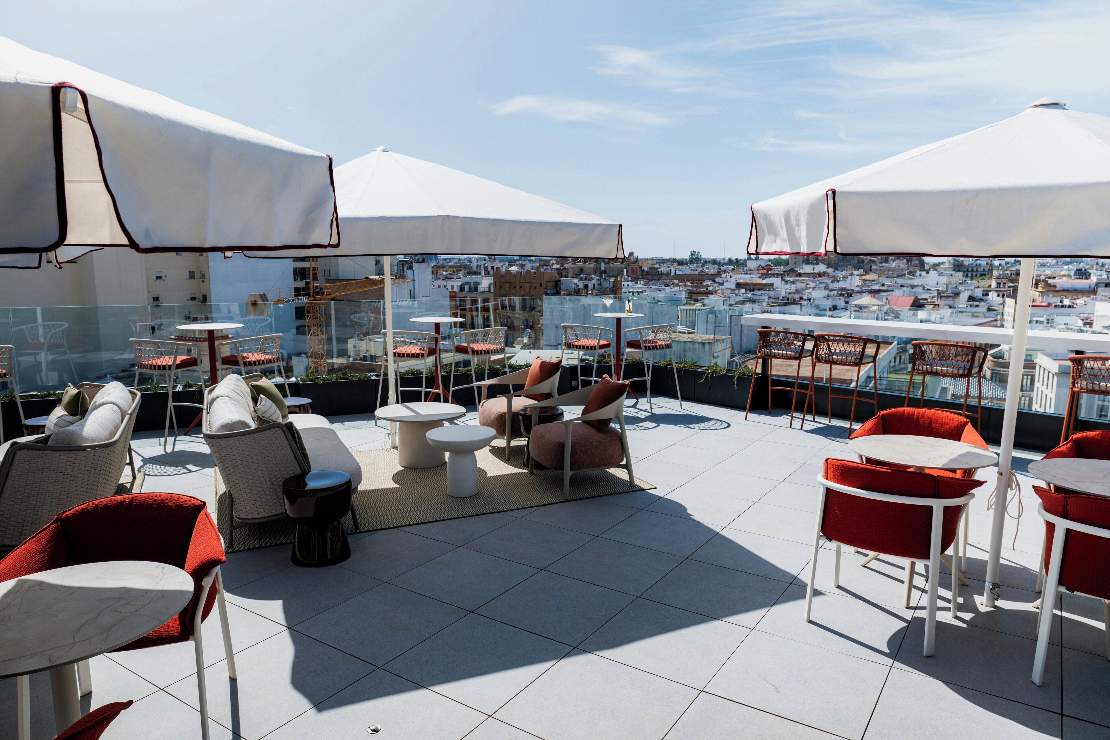 A rooftop terrace with outdoor seating and a city view.