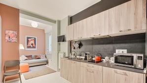 Een moderne keuken met houten kastjes, een magnetron en een waterkoker.