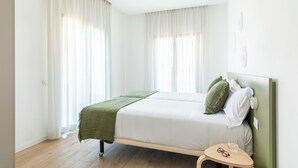 A bedroom with a bed, a bedside table, and a window with curtains. - Líbere Rome San Lorenzo (Rome)