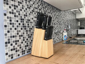 A kitchen with a tiled backsplash, a wooden knife block, a sink, and a bottle of dish soap. - Beautiful 2BR Near AKH Ideal For Groups (Vienna)