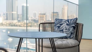 A modern room with a view of a city skyline and water. - StayShort - Elegant 1 Bedroom in EMAAR Beachfront that Sleeps 2 (EMAAR Beachfront)