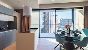 A modern kitchen with a dining area, large windows, and a view of the cityscape. - Mercury Tower (St. Julian's)