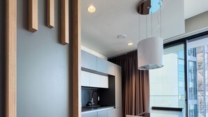 A modern kitchen with grey cabinets, a black countertop, and a pendant light. - Mercury Tower (St. Julian's)