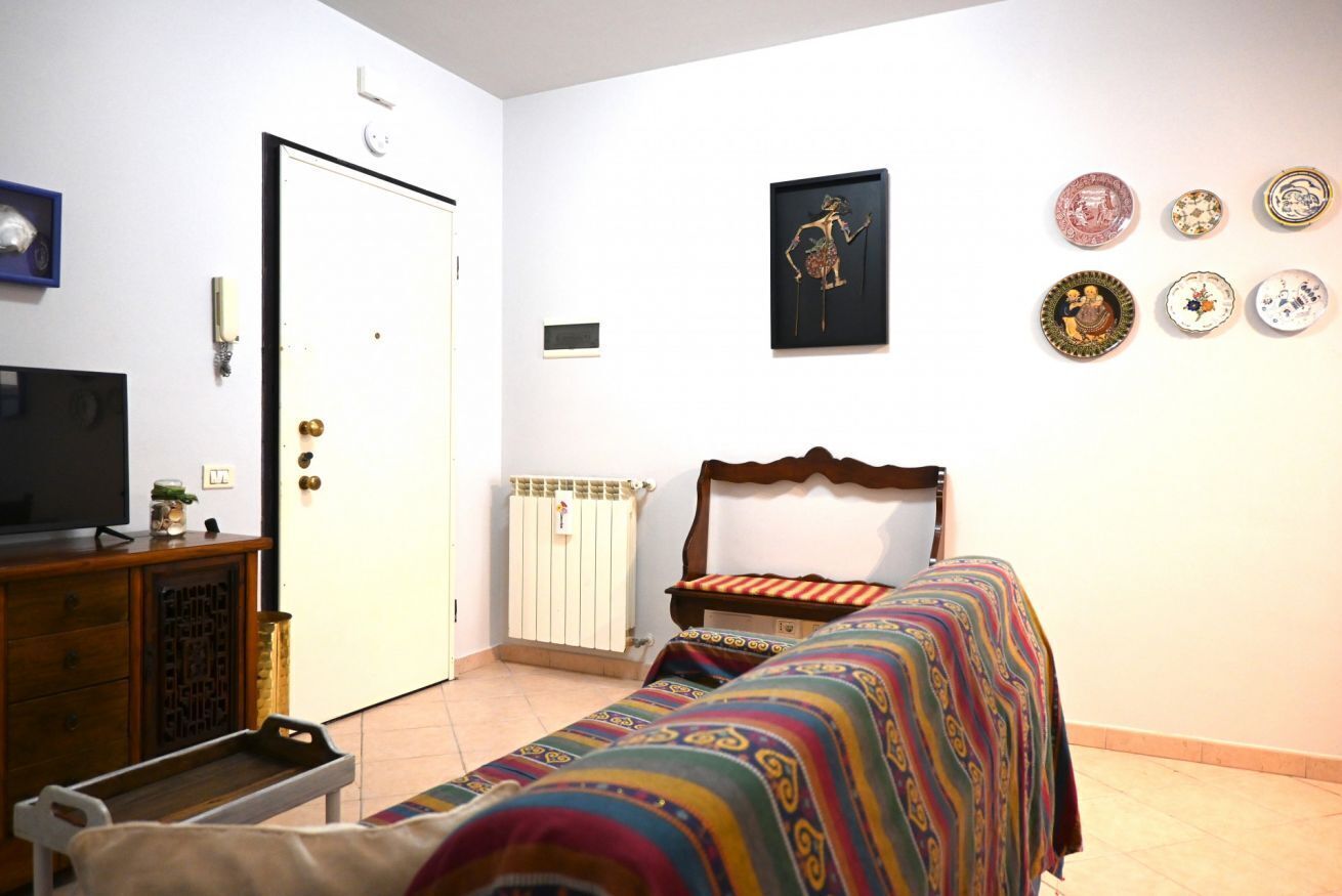 A bedroom with a bed, a dresser, a television, a door, and wall decorations.