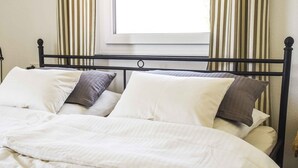 A bed with a headboard, pillows, and a blanket. - Holiday Apartment Im Weiler, 70m², 1 Bedroom, Up to 4 Guests (Winterlingen)