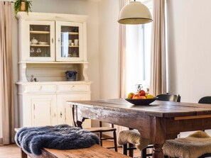 A dining table with a bowl of fruit, a fur throw, and a vintage lamp. - Holiday Apartment Im Weiler, 70m², 1 Bedroom, Up to 4 Guests (Winterlingen)