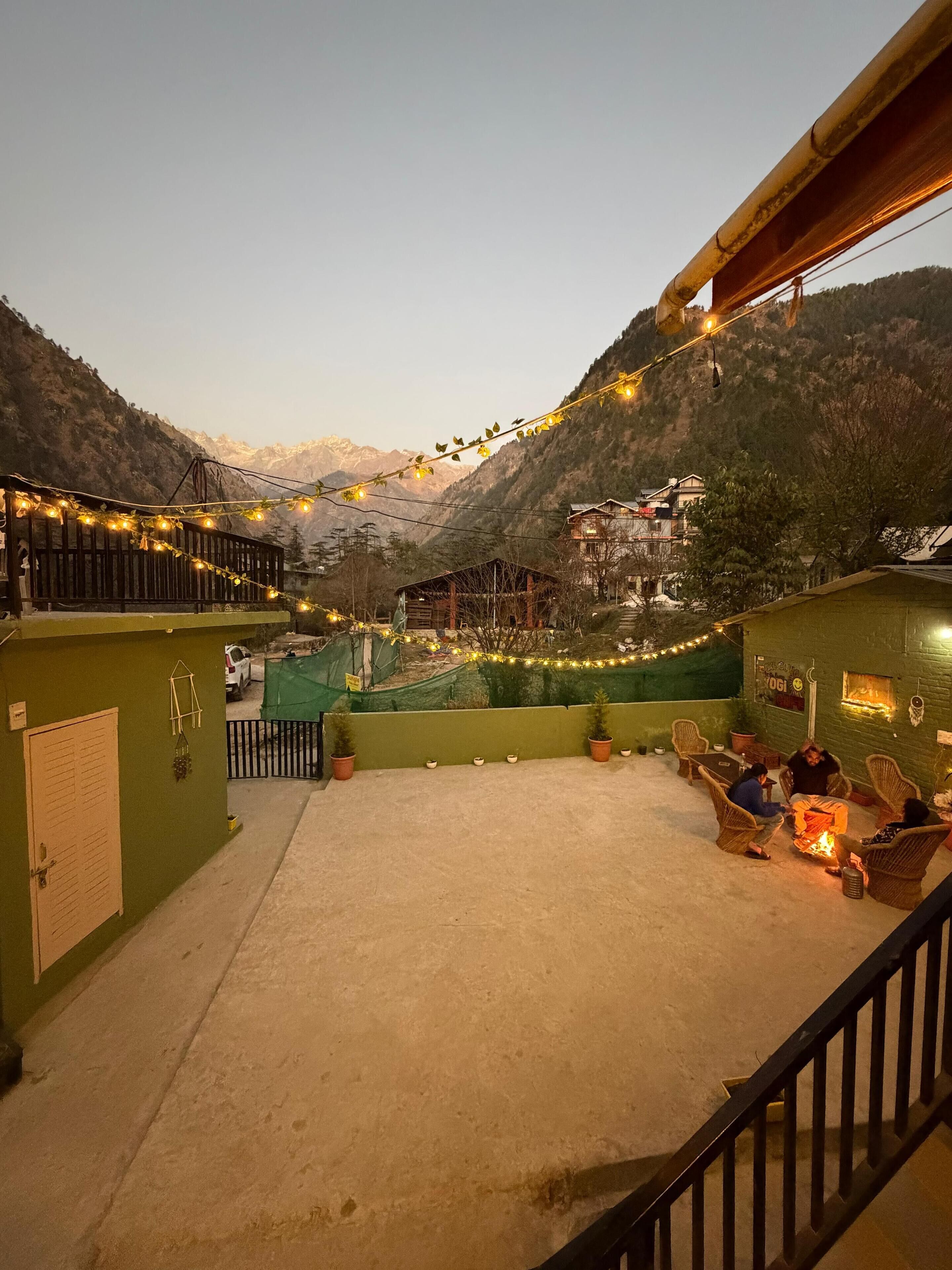 A terrace with outdoor seating and a view of a mountain range.