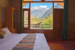 Un dormitorio con un amplio ventanal que ofrece vistas a la montaña.