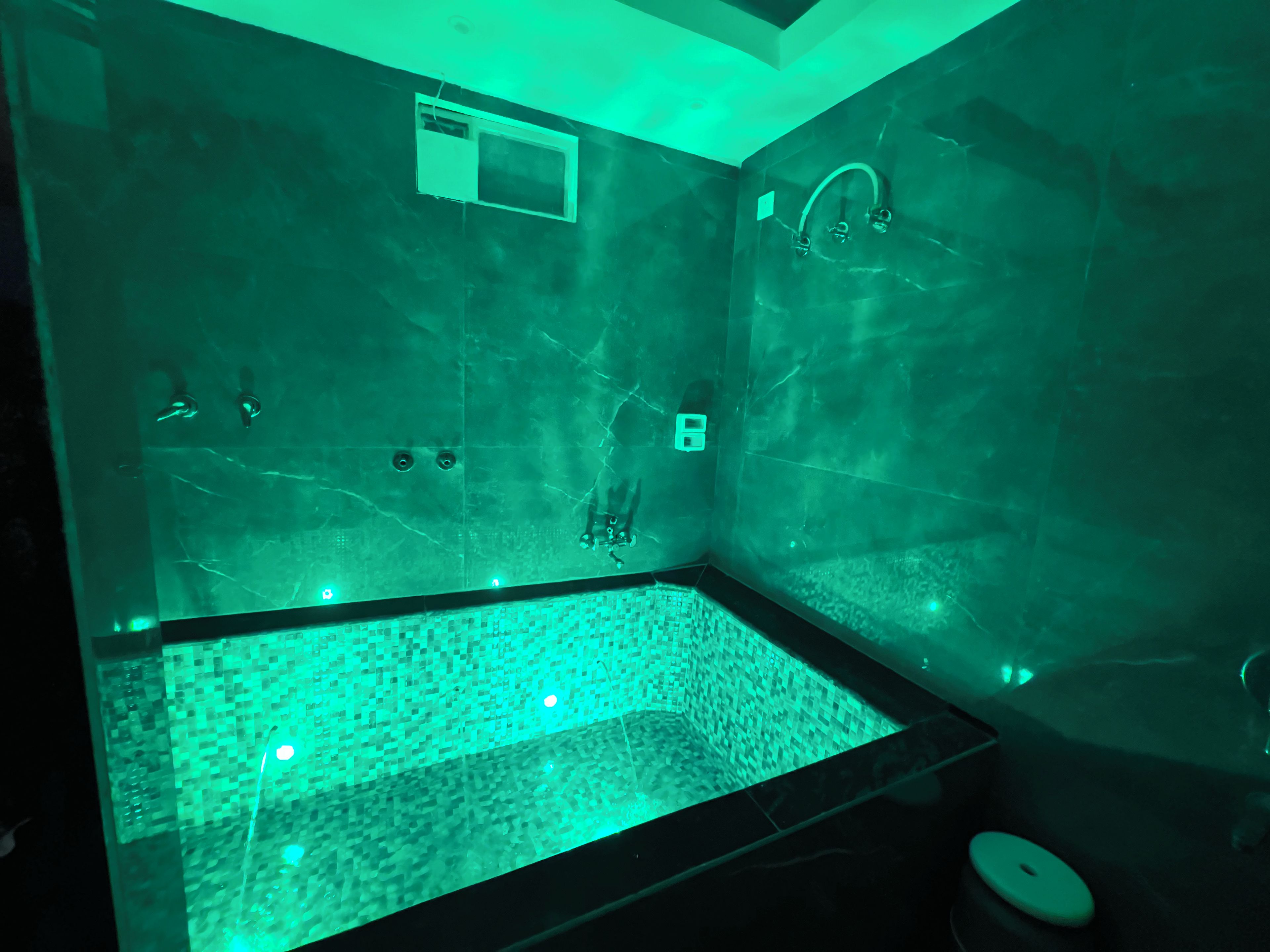 Un baño con suelo de baldosas, ducha e inodoro.