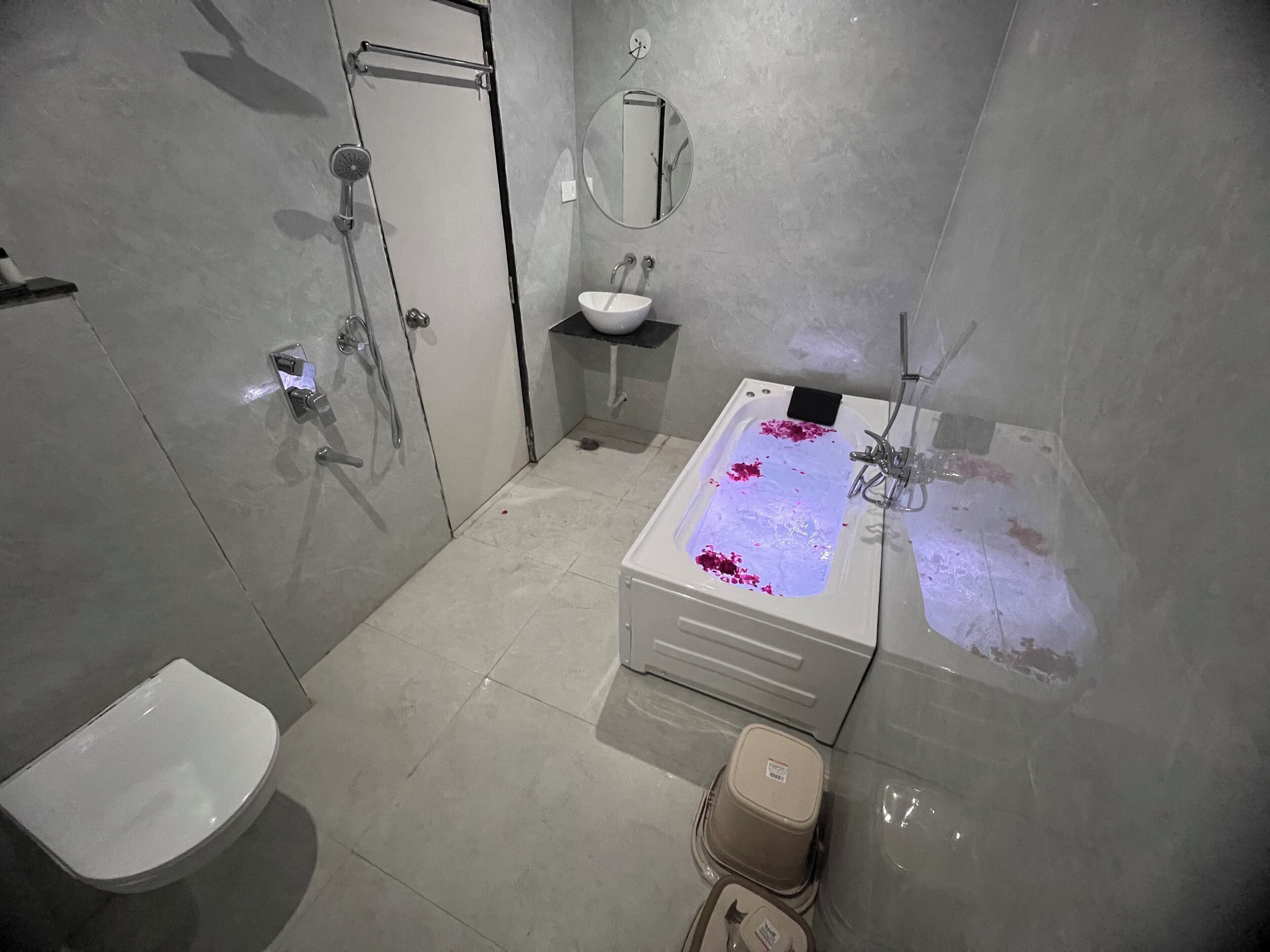 Ein Badezimmer mit Dusche, Waschbecken, Toilette und Spiegel.