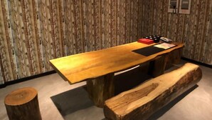 A conference room with a wooden table and benches, a patterned wallpaper background, and a ceiling with recessed lighting. - 128 INN- Self Check In (Taipei)