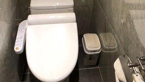 A modern bathroom with a toilet, a bidet, and a trash bin. - 128 INN- Self Check In (Taipei)