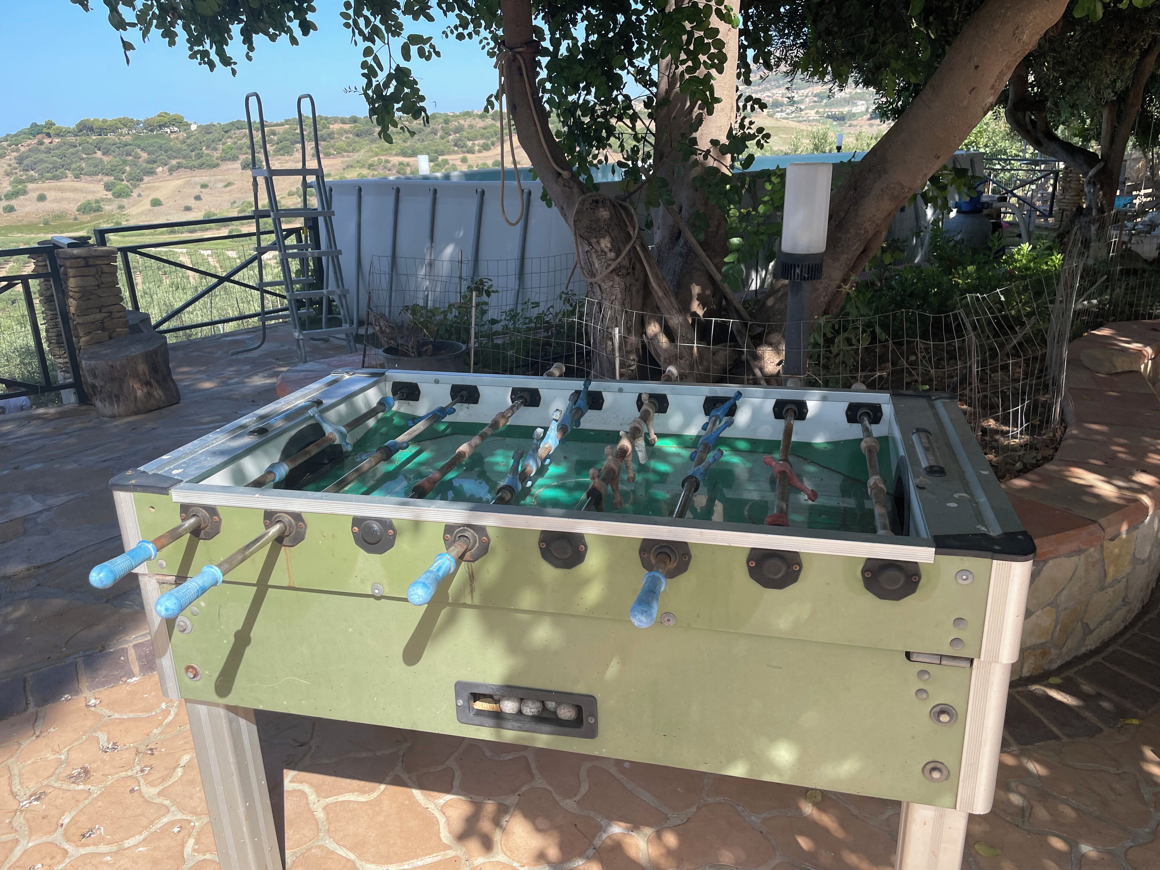 Un tavolo da calcio all'aperto con una vista panoramica sullo sfondo.