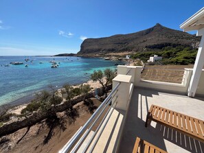A balcony with a view of a coastal area, including boats on the water and a mountain in the background. - One-Bedroom Apartment with Sea View and Terrace (Trapani)