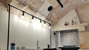 Una cocina con techo de piedra, una cafetera y una encimera con vajilla y cristalería.