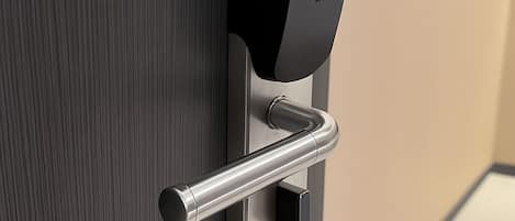 A modern door handle with a metallic finish, a black card slot, and a keyhole.