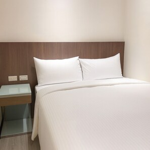 A neatly made bed with white linens in a hotel room. - Warm House (Taipei)