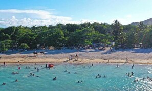 A beach with clear water, people swimming, and palm trees. - Las Indígenas 6BR Pool Jacuzzi Gazebo (Imbert)