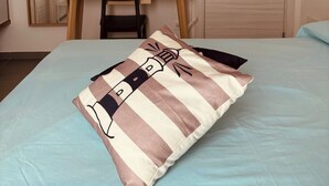 Un dormitori amb un llit, escriptori, cadira, làmpada, armari i aire condicionat.