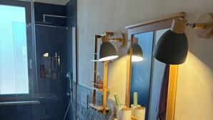 Un bany modern amb un mirall gran, dues làmpades penjants, un lavabo i un vàter.