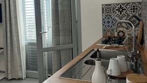 Une cuisine moderne dotée d’un plan de travail en bois, d’un évier et d’un crédence ornée de carreaux à motifs.