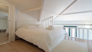 A bedroom with a large bed, wooden flooring, and a balcony with a railing. - L'Arcachon | Hypercentre - Free Parking (Arcachon)