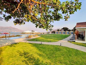 A well-maintained lawn, outdoor seating area, and a building with a distinct architectural style.