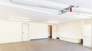 A spacious room with a tiled floor, a bench, a door, and a white cabinet. - Villa Mara - MyHomeinComo (Como)