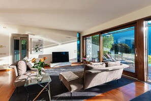Een moderne woonkamer met een bank, televisie en een glazen tafel.