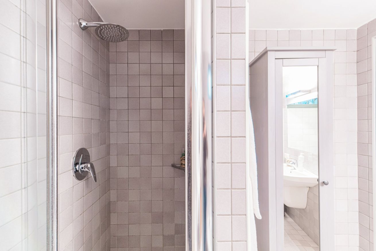 A bathroom with a shower, a toilet, and a sink.