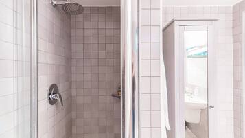 A bathroom with a shower, a toilet, and a sink.