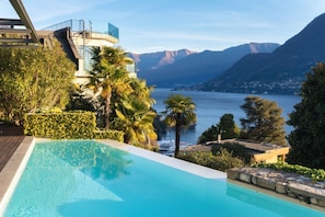 A swimming pool with a view of mountains and a lake.