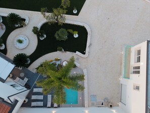 An aerial view of a property with a swimming pool, lounge area, and landscaped garden. - Exclusive detached villa with a heated outdoor pool and spa (Sicilia)