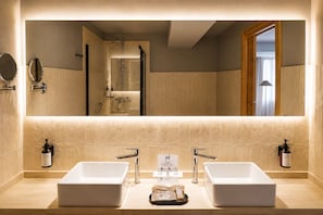 A modern bathroom with two sinks, a large mirror, and a shower visible in the reflection. - Hotel La Palloza (Lugo)