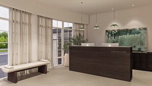 Et moderne receptionområde med en bænk, en skranke og et stort abstrakt maleri på væggen.