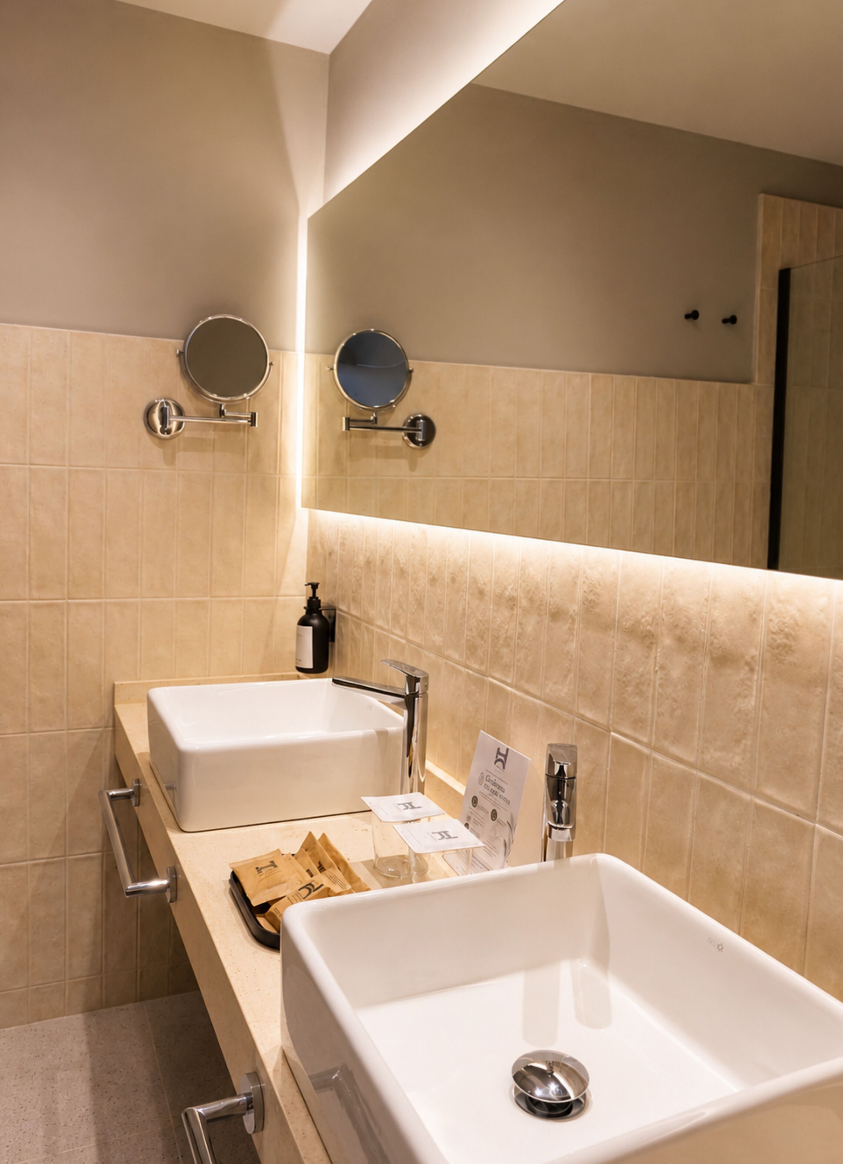 A bathroom with two sinks, a mirror, and a towel rack.