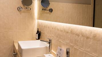 A bathroom with two sinks, a mirror, and a towel rack.