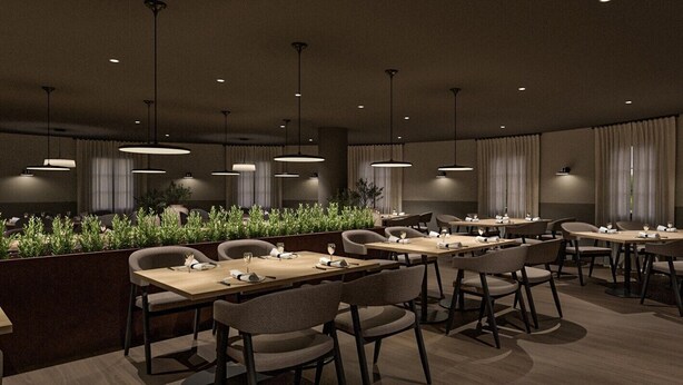 Un espace repas moderne avec plusieurs tables et chaises, des luminaires suspendus et un mur végétal.