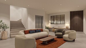 Un salon moderne avec un canapé, des fauteuils, une table basse et un escalier.