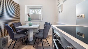 Une cuisine moderne avec une table à manger, des chaises et une cuisinière intégrée.