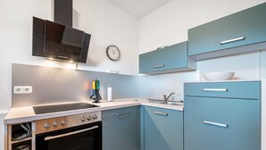 Une cuisine moderne équipée d’un four encastré, d’une plaque de cuisson et d’un four à micro-ondes.