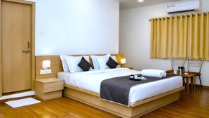 Una camera d'albergo con un letto, comodini, una sedia, una scrivania e una finestra con tende.