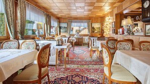 A dining area with tables, chairs, and a patterned carpet. - Hotel Bären – Three-Star: Single Room 9 / Breakfast Included / 1 Person / Balcony / WiFi (Bernau im Schwarzwald)