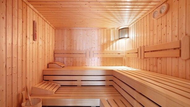 A sauna with wooden benches and a bench seat, wooden walls, and a wall-mounted thermometer. - Hotel Bären – Three-Star: Single Room 9 / Breakfast Included / 1 Person / Balcony / WiFi (Bernau im Schwarzwald)