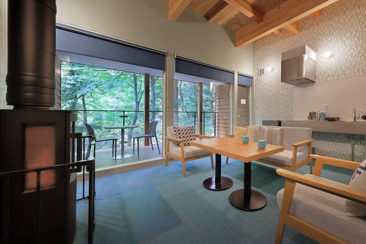 Una sala de estar moderna con un ventanal grande, una chimenea y un comedor.
